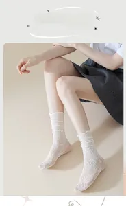 Close-up of white lace mesh calf socks featuring floral patterns and ruffled edges