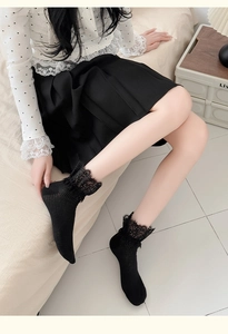Detailed view of black vertical stripe socks with wide lace trim in college style