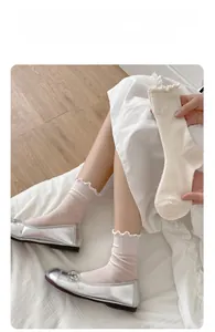 Dettaglio di calze a rete bianco crema con elegante bordo a balze e cotone traspirante