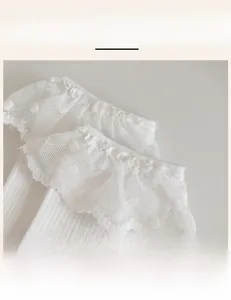 Detail of white cotton socks featuring elastic ribbed cuffs and delicate lace trim design