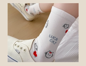 Detailed close-up of white cotton sock featuring Luck Cat cartoon and red heart pattern