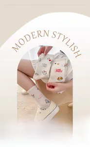 Detail of cute animal patterns and elastic cuff on white cotton mid-calf socks