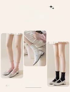 Detailed close-up of polka dot mid-calf socks with ruffled edges in pink, white, and black