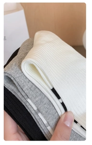 Detail of ribbed knit cotton socks in black, grey, and white with striped accents