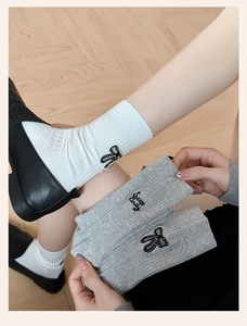 Close-up of ribbed knit socks featuring embroidered bows and Sweet Candy lettering detail