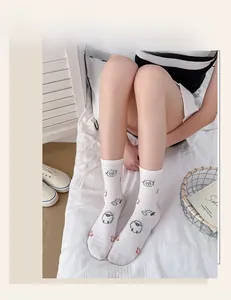 Close-up of white crew socks featuring cartoon sheep and Cool Sheep text embroidery