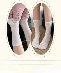 Close-up of white crew socks featuring breathable heart jacquard patterns and ribbed cuffs