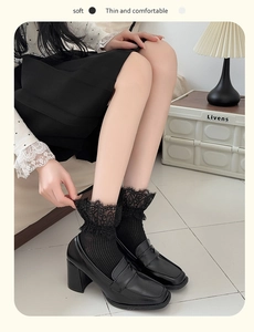 Detail of vintage black loafers with delicate lace trim socks and fine vertical stripes