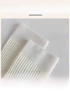 Detail view of the high-elastic ribbed cuff on white knit crew socks for women
