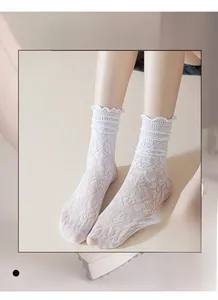Detail of high elasticity white lace mesh socks with ruffled cuffs and floral patterns