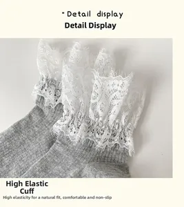 Detailed macro view of the high-elasticity cuff with delicate white lace trim on grey socks