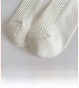 Detailed macro view showing the seamless toe and ribbed texture of white cotton socks