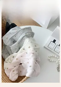 Detailed view of floral embroidered cotton socks with ribbed texture in a woven basket