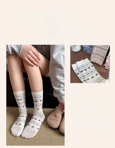 Detail of crew socks featuring heart and bow patterns in soft cream and pink hues