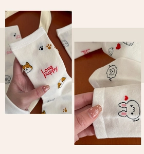 Detailed close-up of white cotton socks featuring cute animal embroidery and ribbed cuffs