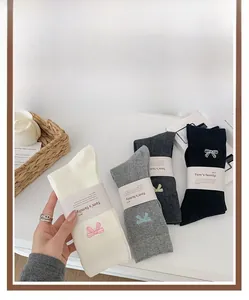 Detailed close-up of bowknot embroidery on assorted crew socks with stylish packaging