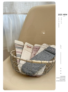 Close-up of cream lace socks with bow details and various knit textures in a basket