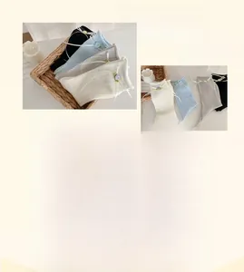 Dettaglio di calze in cotone pettinato con fiocchi, nastri e ricamo floreale delicato