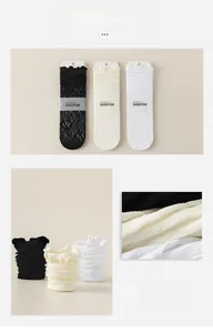 Detailed close-up of hollow lace mesh socks in black, white, and beige with floral texture