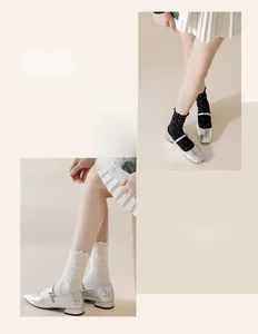 Close-up of polka dot crew socks with ruffled edges styled with silver Mary Jane shoes