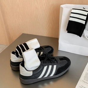 Classic black and white striped crew socks paired with retro leather athletic sneakers