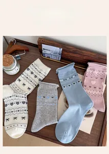 Detail view of heart and bow pattern crew socks in four soft vintage pastel colors
