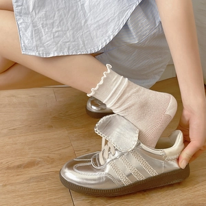 Calze a rete con volant da donna abbinate a sneakers metallizzate argentate