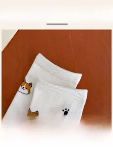 Detail of high-elastic ribbed cuff on white socks with cute Corgi dog patterns