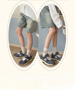 Detail of light blue denim shorts with cute cat embroidery socks and sneakers