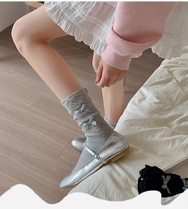 Detail of grey Lolita style mid-tube socks featuring black and white gingham bows and Mary Janes