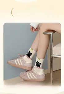 Detail of cotton crew socks with cat print and high-elastic wide cuffs shown with sneakers