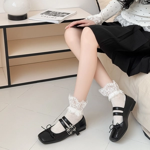 Lace trim socks with black Mary Jane shoes featuring double buckles and bow details