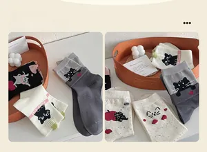 Detail of cute cat pattern socks with spot yarn and 'Cute Cat' embroidery in cozy flat lay