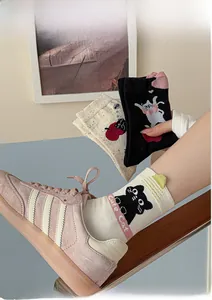 Detail view of cute knit cat socks with 3D ears paired with pink suede sneakers