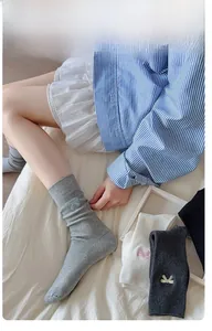 Detailed embroidery bow on a soft cotton blend mid-calf sock shown on a model