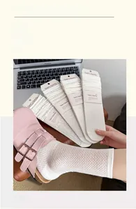 Detail of white hollow-knit crew socks with diamond patterns and cotton mesh texture