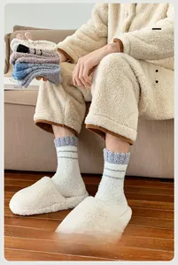 Thick coral fleece socks for men featuring gray and white stripes in a cozy home setting