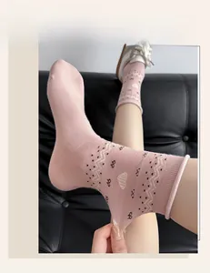 Detailed view of pink cotton crew socks featuring heart and polka dot patterns with ribbed cuffs