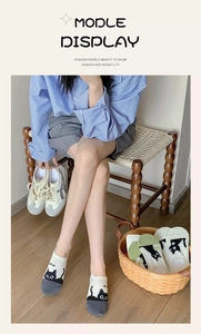 Detail showing cute black cat pattern and anti-slip elastic cuff on beige low cut socks