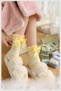 Gros plan de chaussettes en polaire corail avec nœuds décoratifs et motifs à rayures