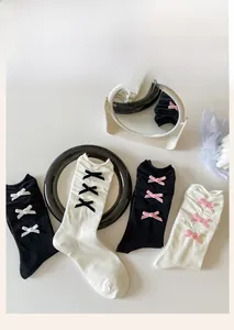 Detail of ballet style bow socks with delicate ribbons and wavy ruffled cuffs