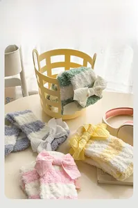 Détail de chaussettes douces en polaire corail à rayures avec nœuds en tons pastels