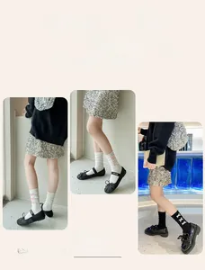 Detail of ballet style bow socks featuring white and black mesh with silk ribbon ties