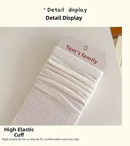 Detail view of high elastic mesh cuffs on breathable white crew socks with brand packaging
