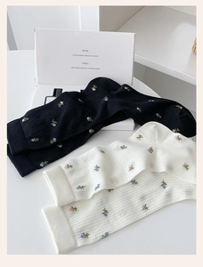 Detailed knit texture of floral mesh crew socks in black and cream beige tones