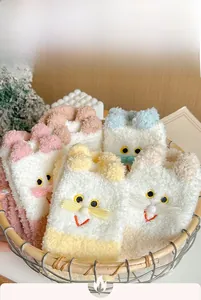 Detail of coral fleece socks with cat embroidery and ears in a basket