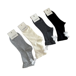 Quattro paia di calzini in cotone grigio e nero con pizzo e fiocco in confezione