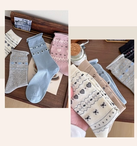 Detail of vintage heart and bow knit socks in various colors with textured floral patterns