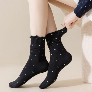 Polka dot crew socks for women featuring ruffled edges and cozy cotton knit material