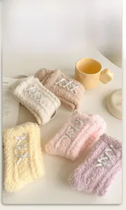 Detail of five pairs of warm coral fleece crew socks with cute silk bow accents